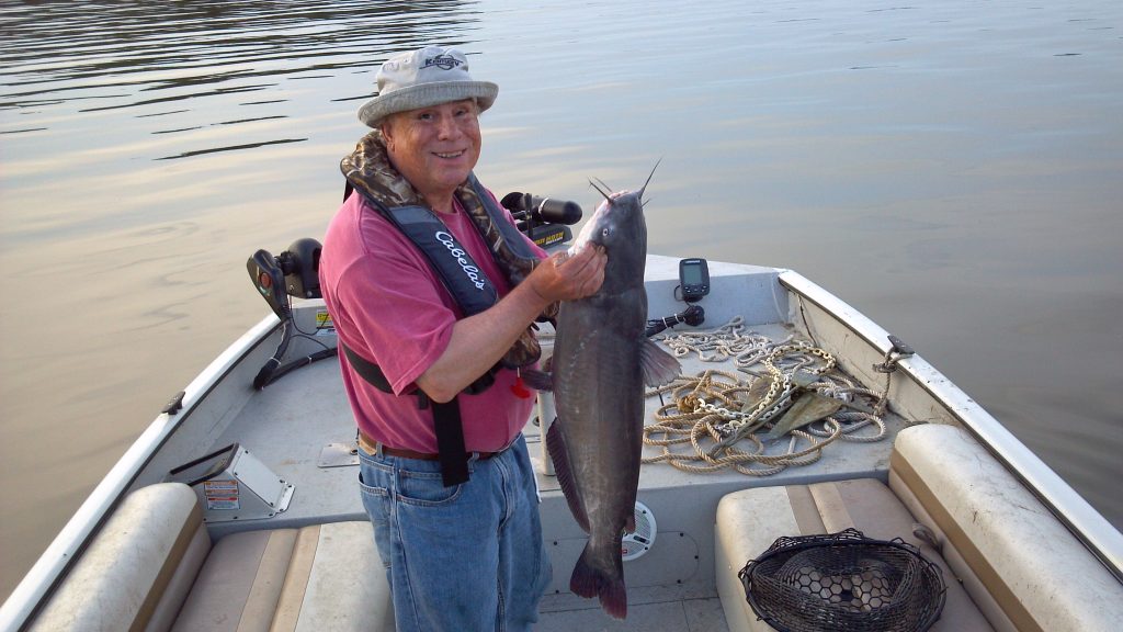 Ron in his boat with big catfish